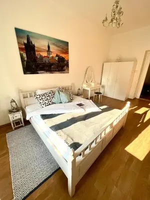 a bedroom with a white bed and a painting on the wall at TOP lokalita u Pražského hradu! in Prague