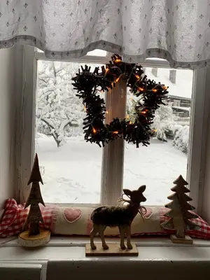 a window with a reindeer and christmas trees on a window sill at Bezva relax Bezděz in Luka