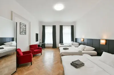 a living room with three beds and a red chair at WSP Petrin Garden Apartments in Prague