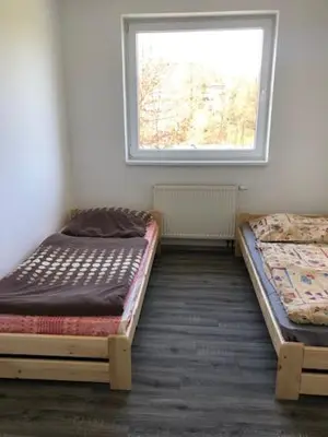 two beds in a room with a window at UBYTOVNA SK Posázavan Poříčí nad Sázavou in Poříčí nad Sázavou