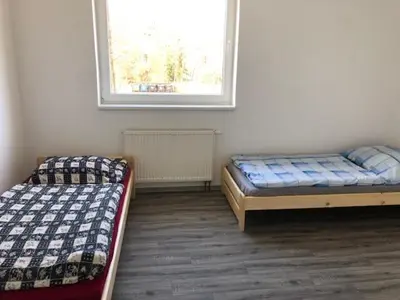 two beds sitting in a room with a window at UBYTOVNA SK Posázavan Poříčí nad Sázavou in Poříčí nad Sázavou