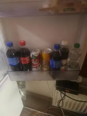 a shelf with a bunch of soda bottles on it at Vila Barrandov in Prague