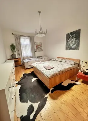 a bedroom with a bed on a wooden floor at Artistic apartment with a balcony in Prague