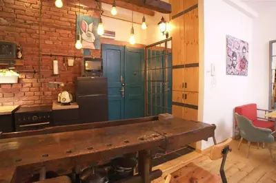 a kitchen with a wooden table and a brick wall at Artistic apartment with a balcony in Prague