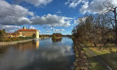 a river with a building on the side of it at Solitaire in Poděbrady