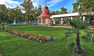 a building with a red roof and a garden with flowers at Solitaire in Poděbrady
