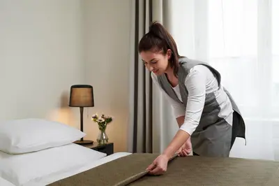 a woman standing next to a bed in a hotel room at Residence Vocelova in Prague
