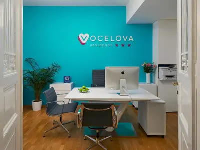an office with a desk with a computer on a blue wall at Residence Vocelova in Prague