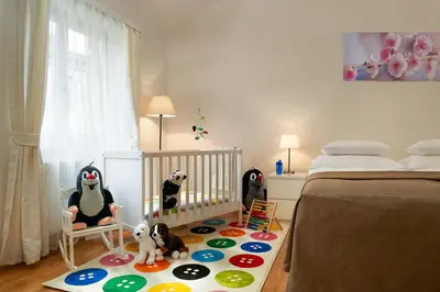 a childs bedroom with a crib and stuffed animals at Residence Vocelova in Prague