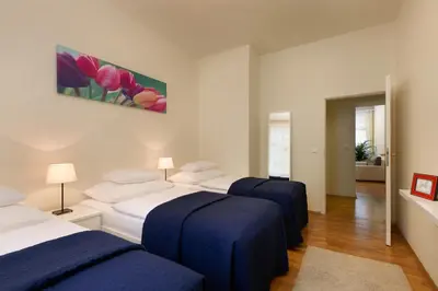three beds in a room with blue and white at Residence Vocelova in Prague