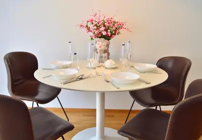 a white table with chairs and a vase of flowers at Apartment with Free Parking in Prague in Prague