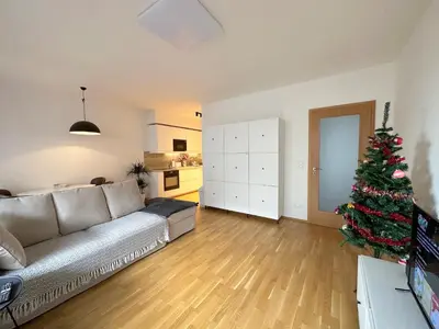 a living room with a couch and a christmas tree at Apartment with Free Parking in Prague in Prague