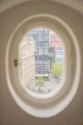 a view of a city from a round window at FREE PARKING- Cozy apartment in historical building center Prague in Prague