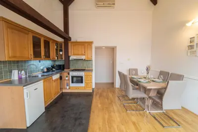 a kitchen with wooden cabinets and a table with chairs at FREE PARKING- Cozy apartment in historical building center Prague in Prague