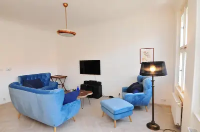 a living room with two blue chairs and a tv at Prague OLD TOWN Cozy Luxury Apartman in Heart of City in Prague