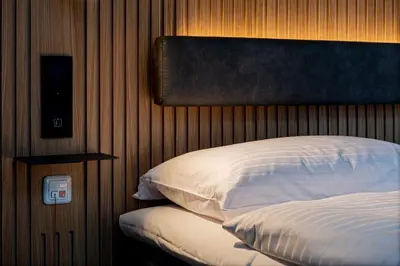 a bedroom with a bed and a wooden wall at Zleep Hotel Prague in Prague