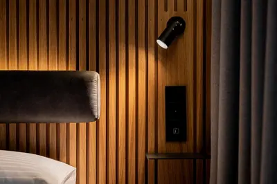 a bedroom with a bed and a light on a wall at Zleep Hotel Prague in Prague