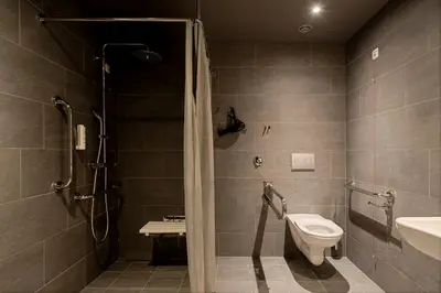 a bathroom with a shower and a toilet and a sink at Zleep Hotel Prague in Prague