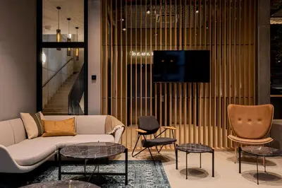 a living room with a couch and tables and a tv at Zleep Hotel Prague in Prague