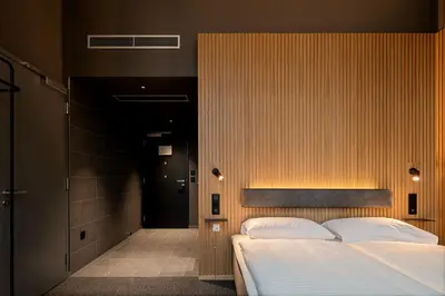 a bedroom with a large bed and a hallway at Zleep Hotel Prague in Prague