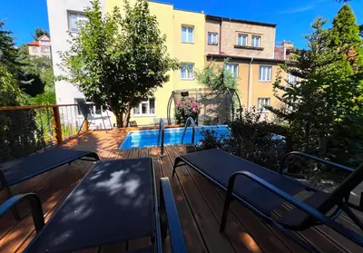 a deck with two benches and a swimming pool at Apartmán III Praha - centrum in Prague