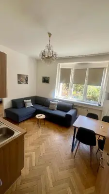 a living room with a blue couch and a table at Apartmán III Praha - centrum in Prague