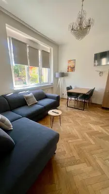 a living room with a blue couch and a table at Apartmán III Praha - centrum in Prague