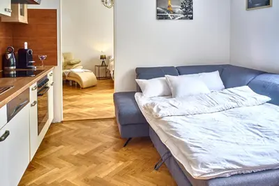 a living room with a couch and a kitchen at Apartmán III Praha - centrum in Prague