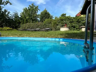 a swimming pool with blue water in a yard at Chalupa Měňany - Karlštejn in Beroun
