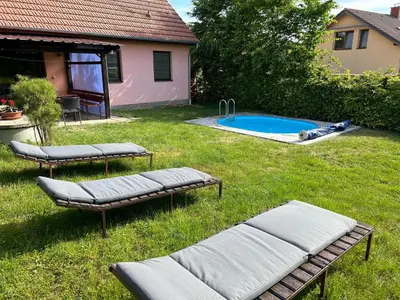 a backyard with two chaises and a swimming pool at Chalupa Měňany - Karlštejn in Beroun