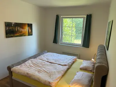 a bed in a room with a window at Chalupa Měňany - Karlštejn in Beroun