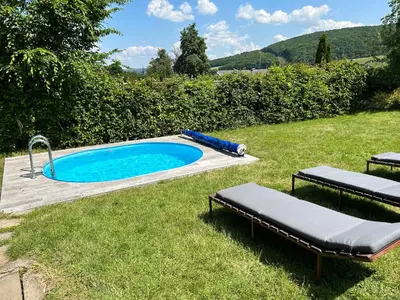 a swimming pool in a yard with two loungers in the grass at Chalupa Měňany - Karlštejn in Beroun