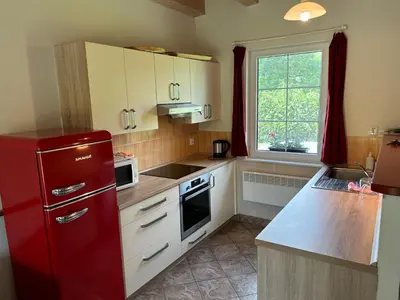 a kitchen with a red refrigerator and a window at Chalupa Měňany - Karlštejn in Beroun