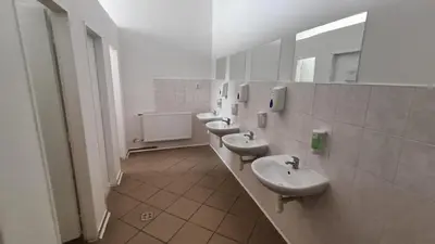 a bathroom with three sinks and a row of mirrors at A Plus Hostel - Centrum in Prague
