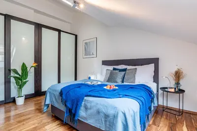 a bedroom with a bed with a blue blanket at Prague Days - SAttic Apartment with AC next to Old Town Square in Prague