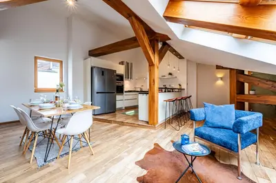 a kitchen and living room with a table and chairs at Prague Days - SAttic Apartment with AC next to Old Town Square in Prague