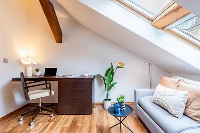 an attic office with a desk and a couch at Prague Days - SAttic Apartment with AC next to Old Town Square in Prague