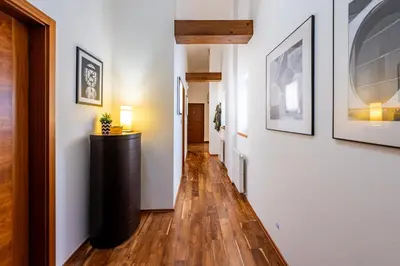 a hallway with white walls and wood floors and a dresser at Prague Days - SAttic Apartment with AC next to Old Town Square in Prague