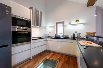 a kitchen with white cabinets and a glass window at Prague Days - SAttic Apartment with AC next to Old Town Square in Prague
