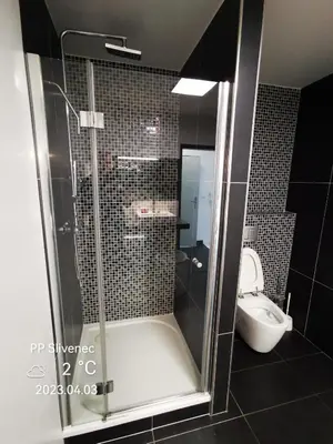 a bathroom with a shower and a toilet at RUMAKO apartments in Prague