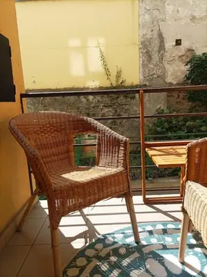 a wicker chair sitting on top of a balcony at Zizkov studio -004- in Prague