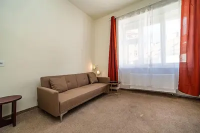 a living room with a couch and a large window at Modern, bright studio in a great location in Prague