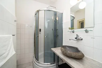a bathroom with a sink and a glass shower at Modern, bright studio in a great location in Prague