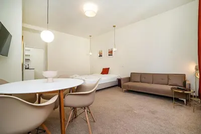 a living room with a bed and a table and chairs at Modern, bright studio in a great location in Prague