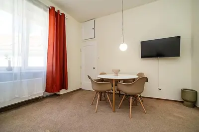 a dining room with a table and chairs and a television at Modern, bright studio in a great location in Prague