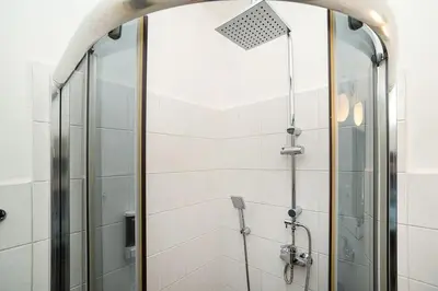 a shower with a glass door in a bathroom at Modern, bright studio in a great location in Prague