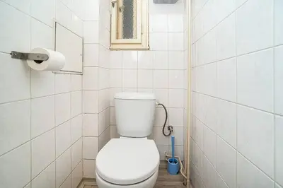 a bathroom with a white toilet and a window at Modern, bright studio in a great location in Prague