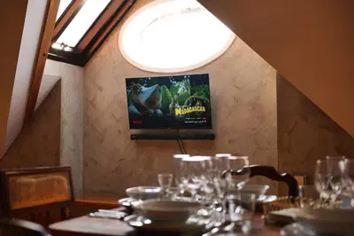 a dining room with a table with glasses and a television at Prague Castle King's Chic in Prague
