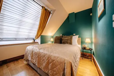 a bedroom with a bed and a green wall at Prague Castle King's Chic in Prague