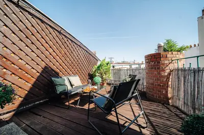 a patio with two chairs and a brick wall at Prague Castle King's Chic in Prague